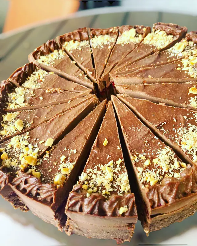 Čokoladna raw torta isečena na parčad, vide se slojevi kore i kreme